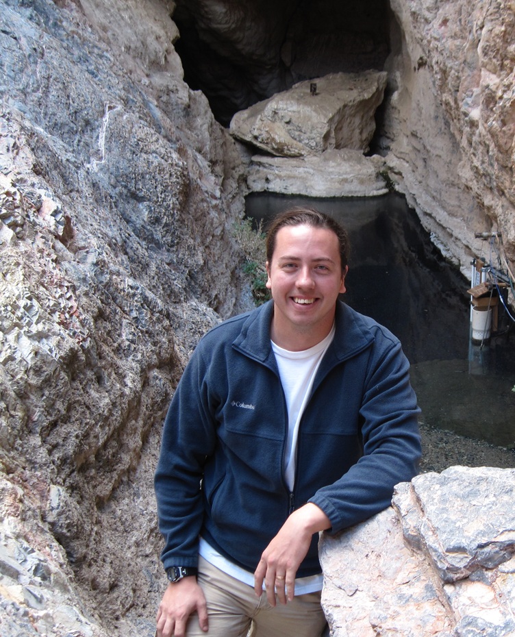 Chris Martin sitting among rocks